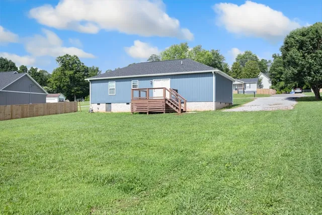 a house that is sitting in the grass with large trees