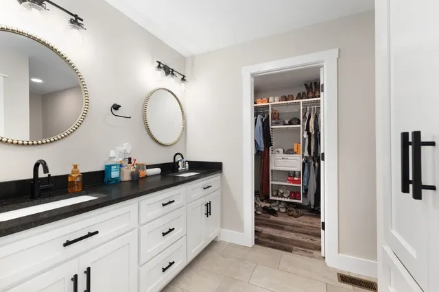 a bathroom with a double vanity sink and a mirror