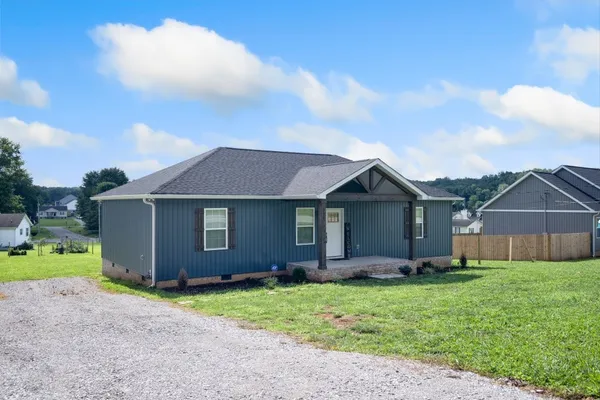 a view of a house with a yard and wooden fence