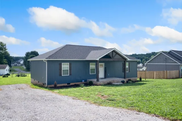 a view of a house with a yard and wooden fence