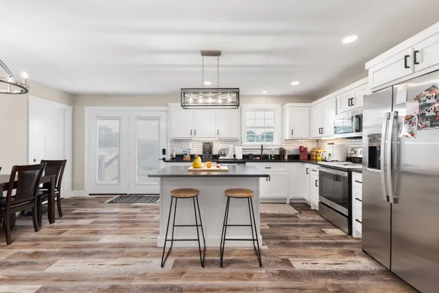 a kitchen with a refrigerator a stove a dining table and chairs