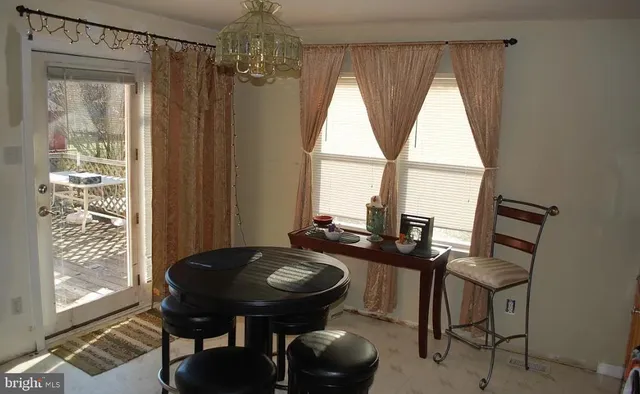 a kitchen with stainless steel appliances granite countertop a table chairs and a wooden floor