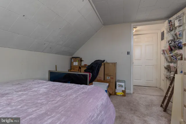 a bedroom with a bed and a flat tv screen on the dresser