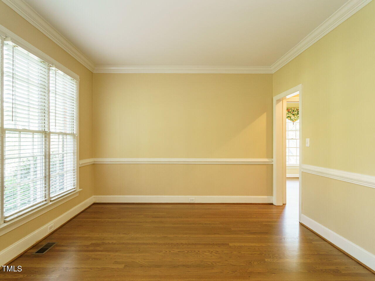 2320 Primrose Valley Court Raleigh, NC 27613 - Photo 6 of 43 a view of an empty room with wooden floor and a window
