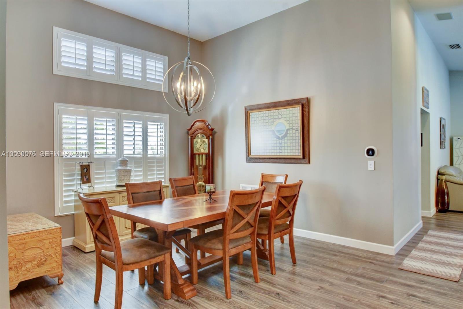 22324 Boyaca Avenue Boca Raton, FL 33433 - Photo 11 of 51 a view of a dining room with furniture a chandelier and wooden floor