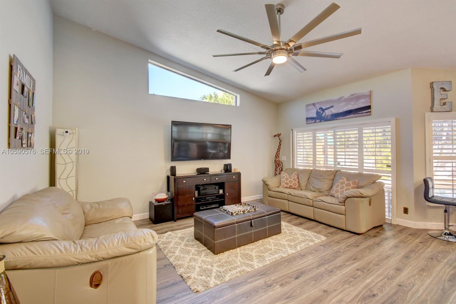 22324 Boyaca Avenue Boca Raton, FL 33433 - Photo 14 of 51 a living room with furniture a large window and a flat screen tv