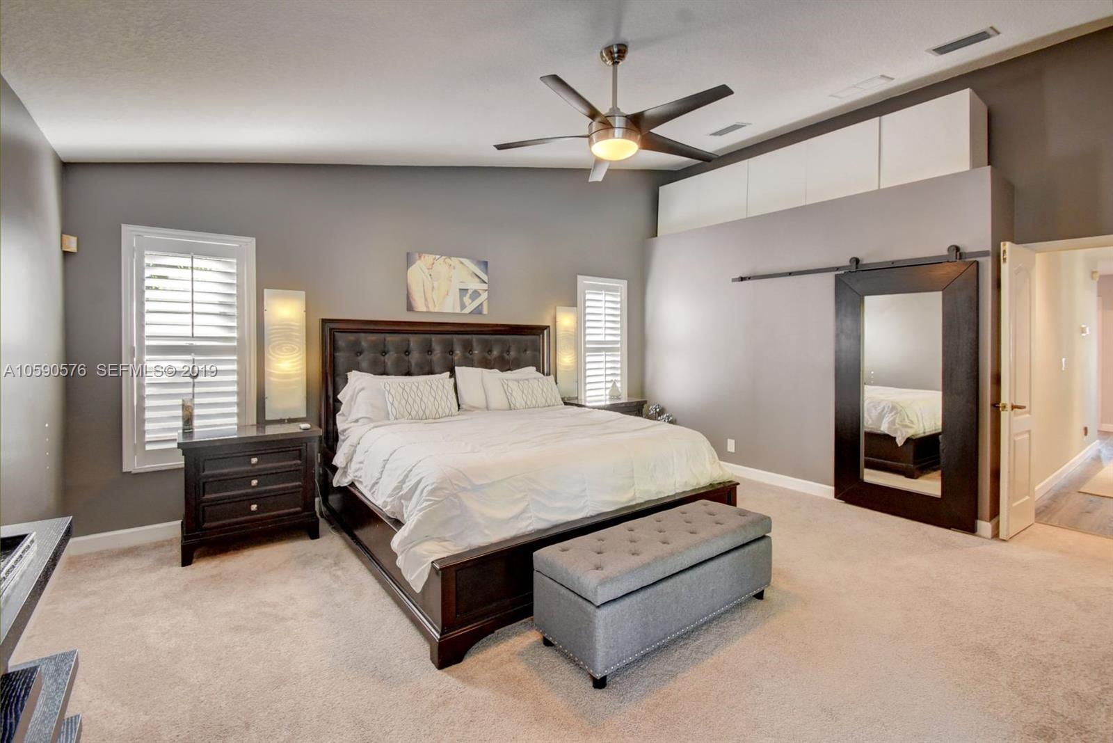 22324 Boyaca Avenue Boca Raton, FL 33433 - Photo 16 of 51 a spacious bedroom with a bed and a mirror