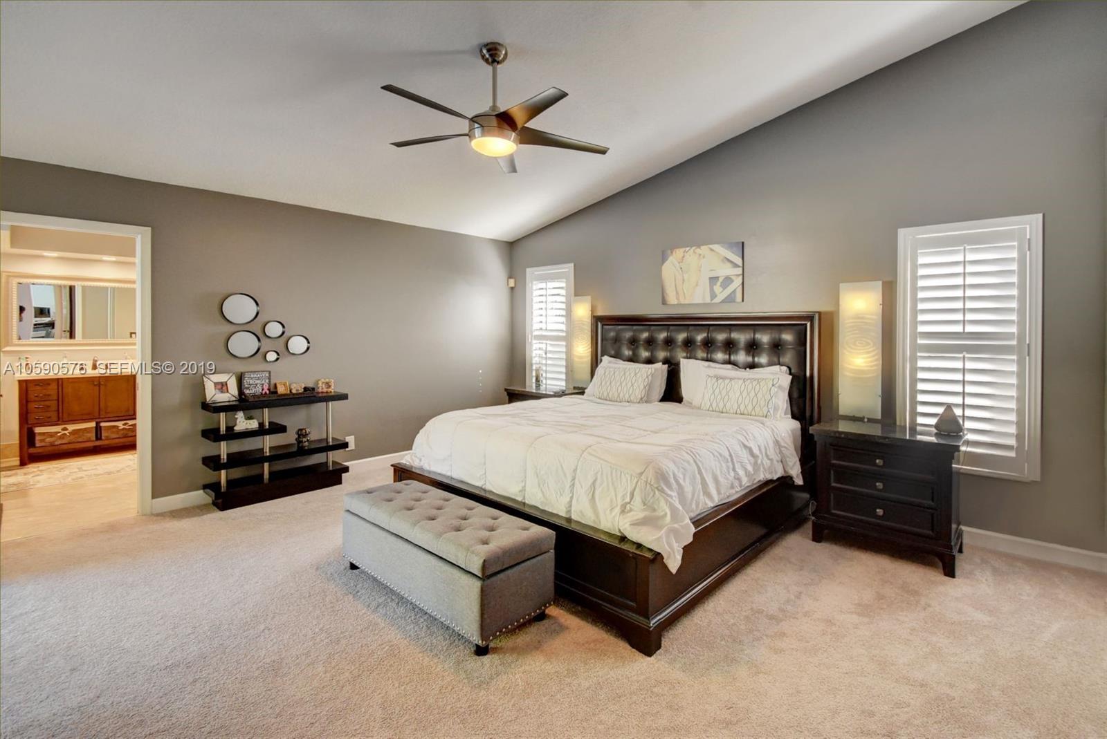 22324 Boyaca Avenue Boca Raton, FL 33433 - Photo 17 of 51 a spacious bedroom with a bed and a chandelier