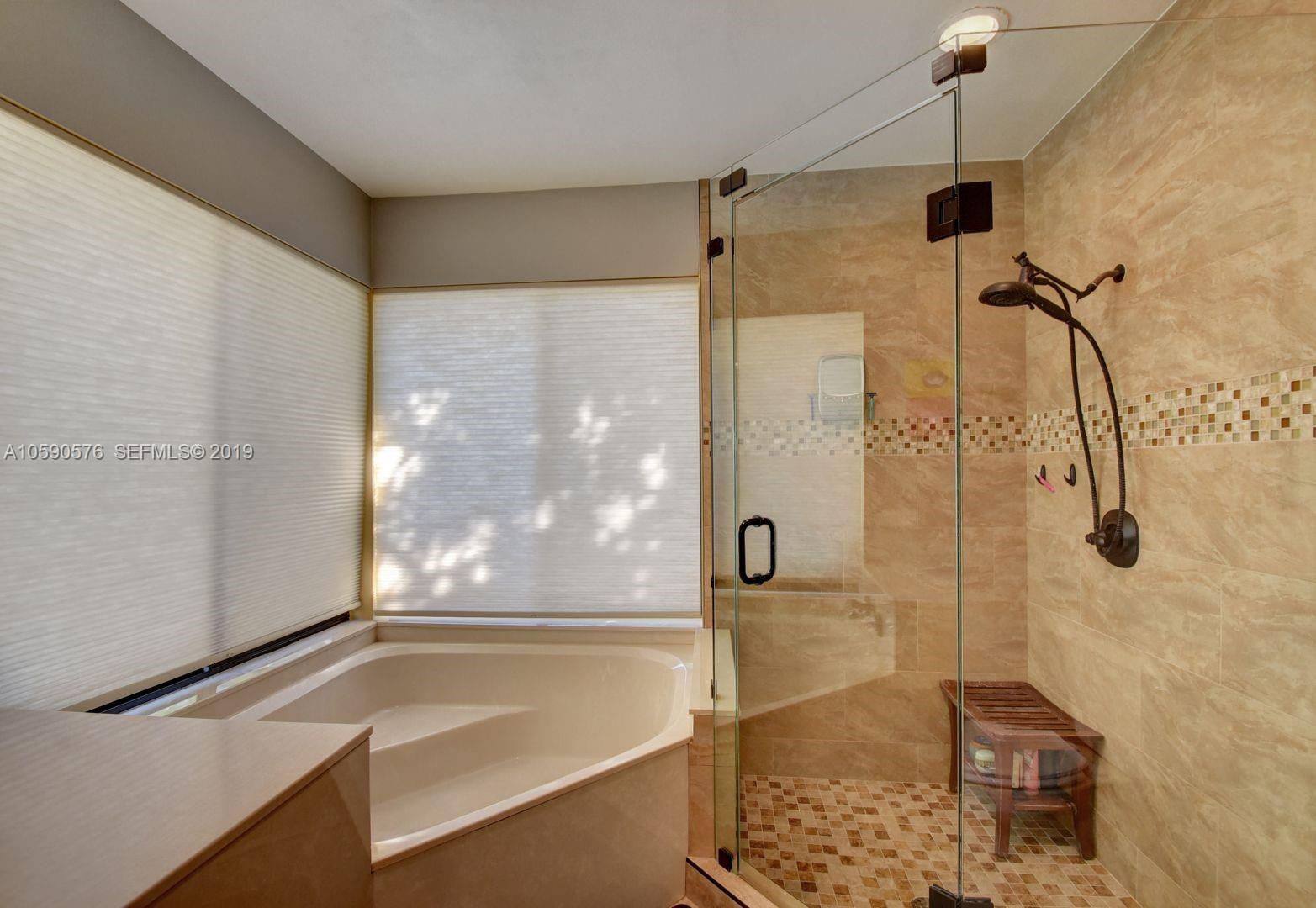 22324 Boyaca Avenue Boca Raton, FL 33433 - Photo 19 of 51 a bathroom with a shower and a tub