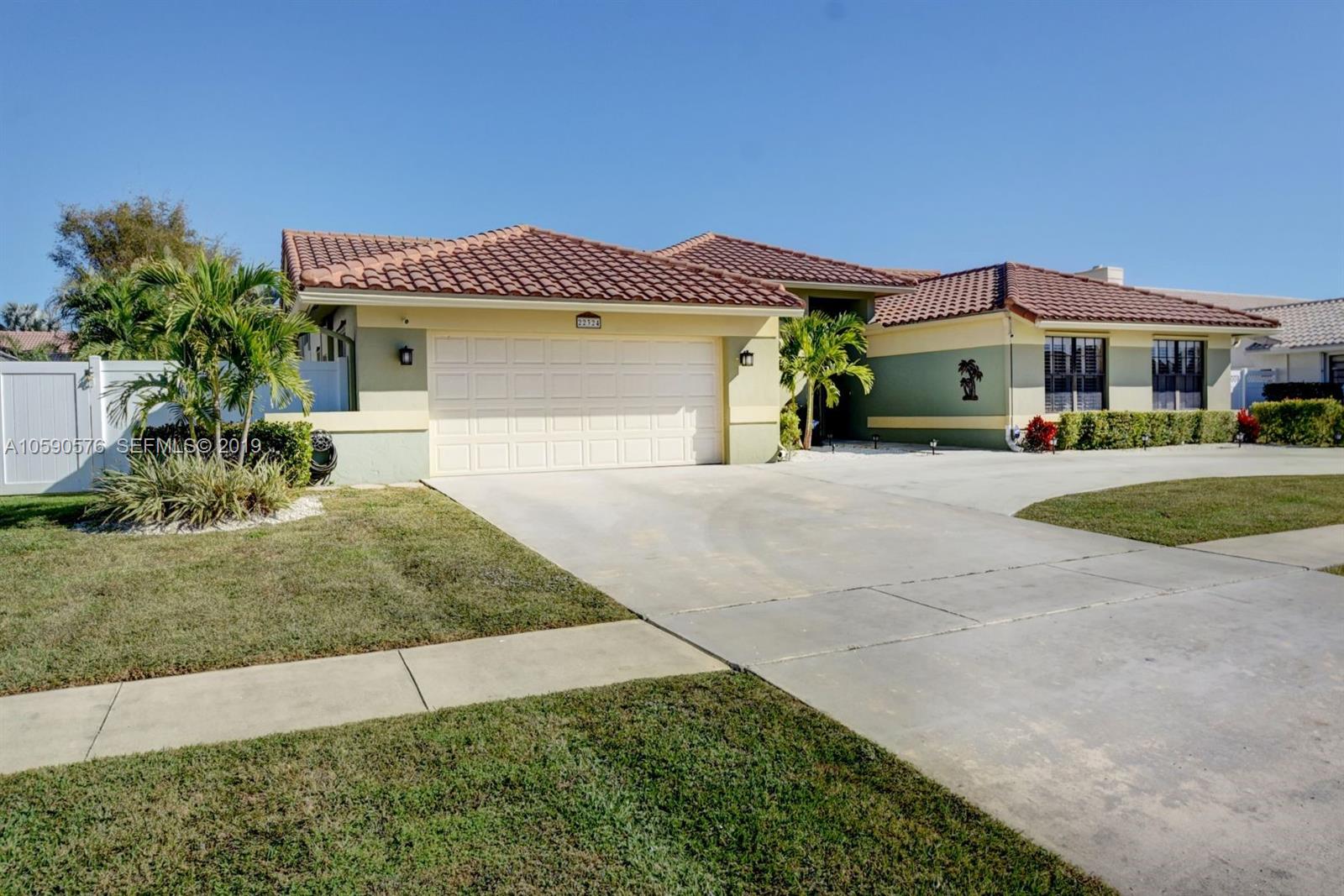 22324 Boyaca Avenue Boca Raton, FL 33433 - Photo 26 of 51 a front view of a house with a yard and garage