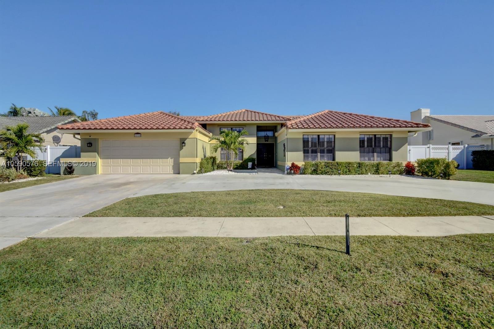 22324 Boyaca Avenue Boca Raton, FL 33433 - Photo 29 of 51 a front view of a house with a yard