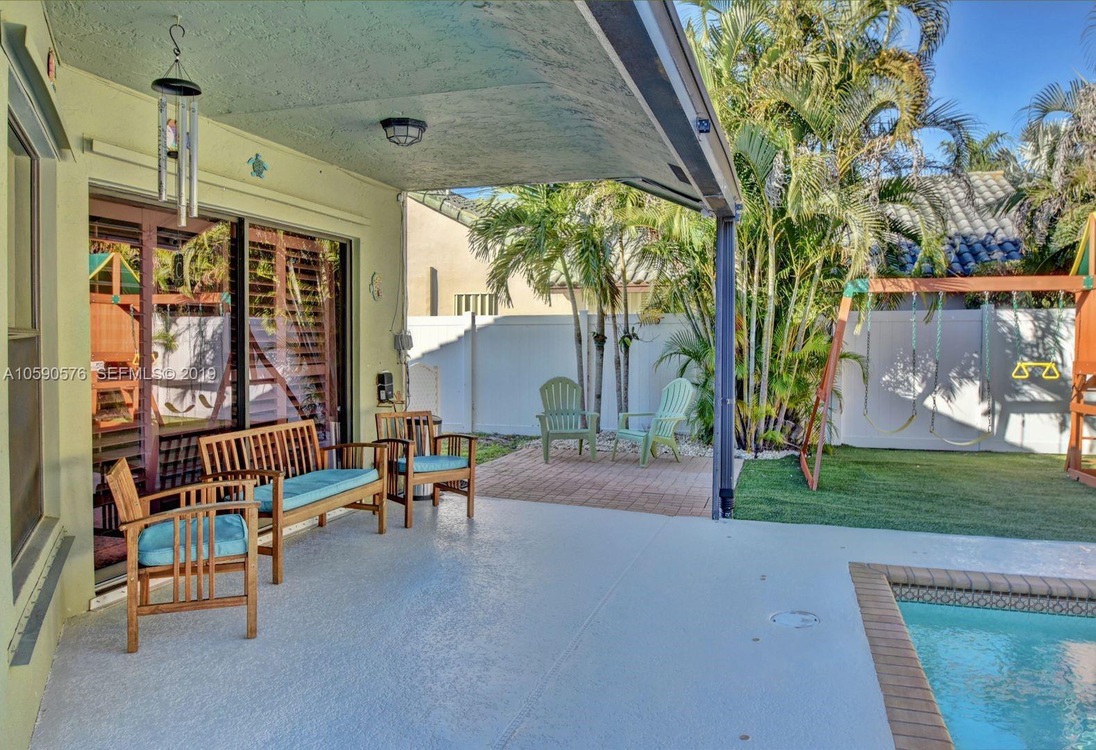 22324 Boyaca Avenue Boca Raton, FL 33433 - Photo 32 of 51 a view of a porch with chairs and a yard