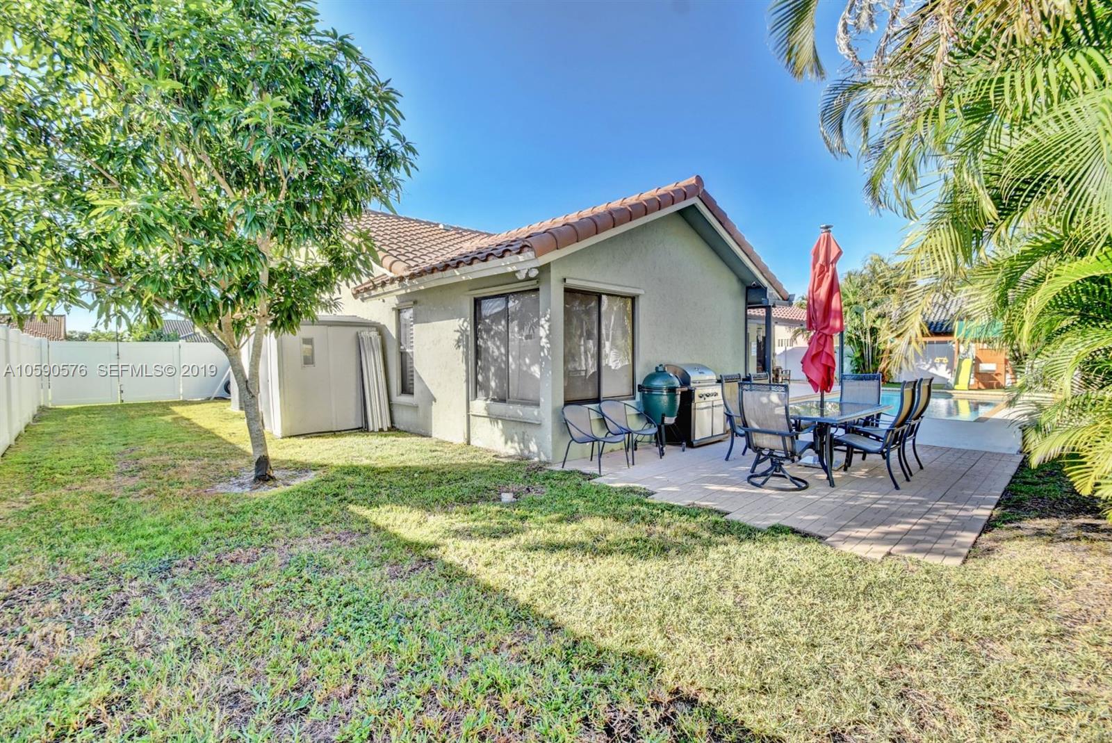 22324 Boyaca Avenue Boca Raton, FL 33433 - Photo 39 of 51 a view of backyard of house with outdoor seating and green space