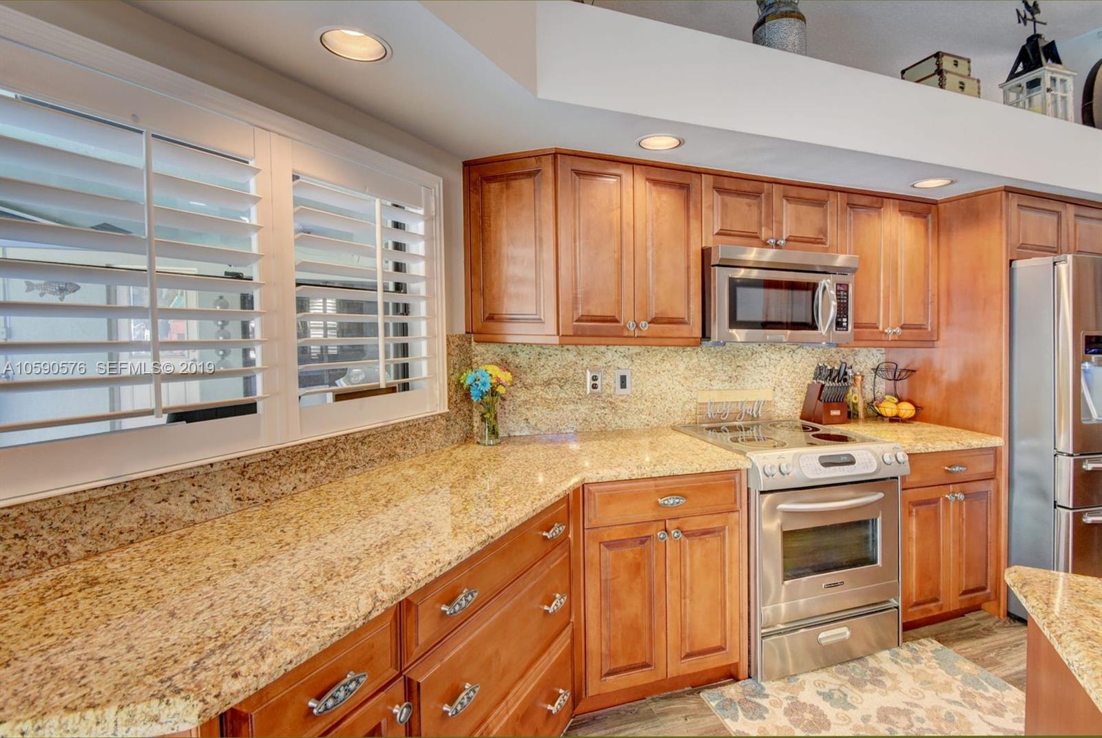 22324 Boyaca Avenue Boca Raton, FL 33433 - Photo 5 of 51 a kitchen with stainless steel appliances granite countertop a stove a sink and a microwave
