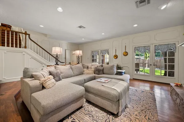a living room with furniture and a wooden floor