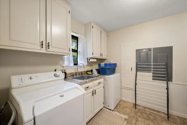 a utility room with cabinets washer and dryer