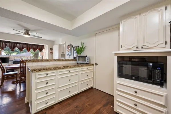 a kitchen with granite countertop a stove and a wooden floor