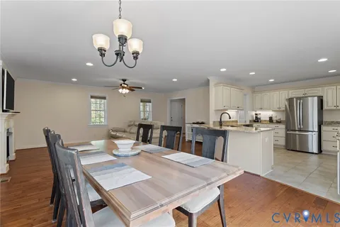 a kitchen with a dining table chairs stainless steel appliances and cabinets