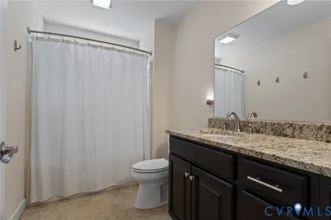 a bed sitting in a bedroom next to a window and a chandelier