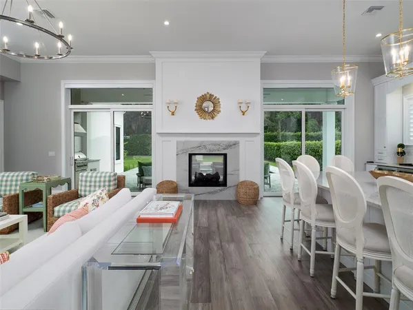 a living room with furniture a fireplace and a floor to ceiling window