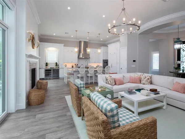 a living room with furniture kitchen view and a chandelier