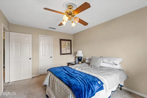 a bedroom with a large bed and a chandelier
