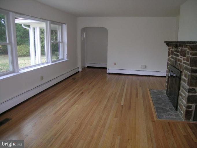 9217 Frederick Road Ellicott City, MD 21042 - Photo 2 of 22 a view of a livingroom with wooden floor and a fireplace