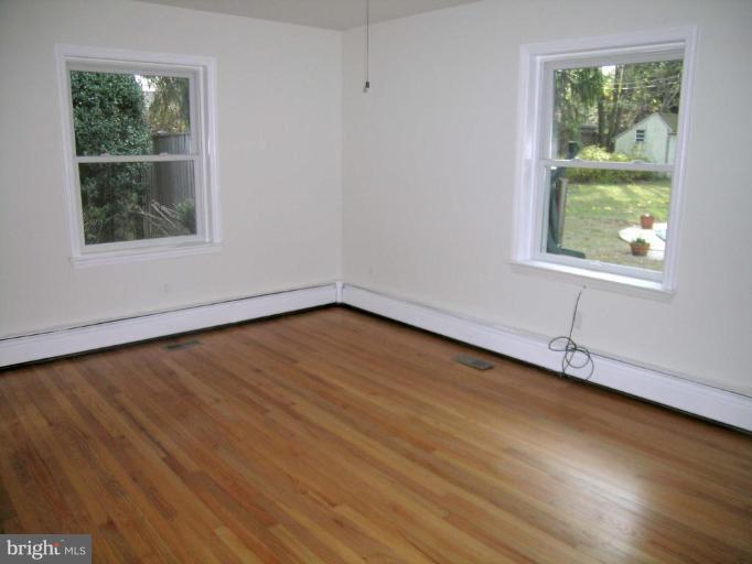 9217 Frederick Road Ellicott City, MD 21042 - Photo 13 of 22 an empty room with wooden floor and windows