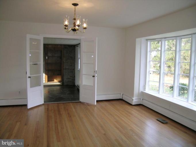 9217 Frederick Road Ellicott City, MD 21042 - Photo 3 of 22 wooden floor in an empty room with a window