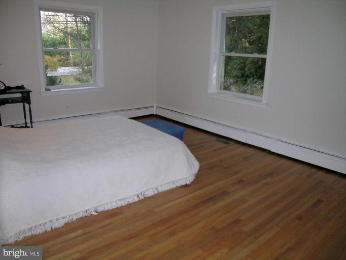 9217 Frederick Road Ellicott City, MD 21042 - Photo 6 of 22 an empty room with wooden floor and windows