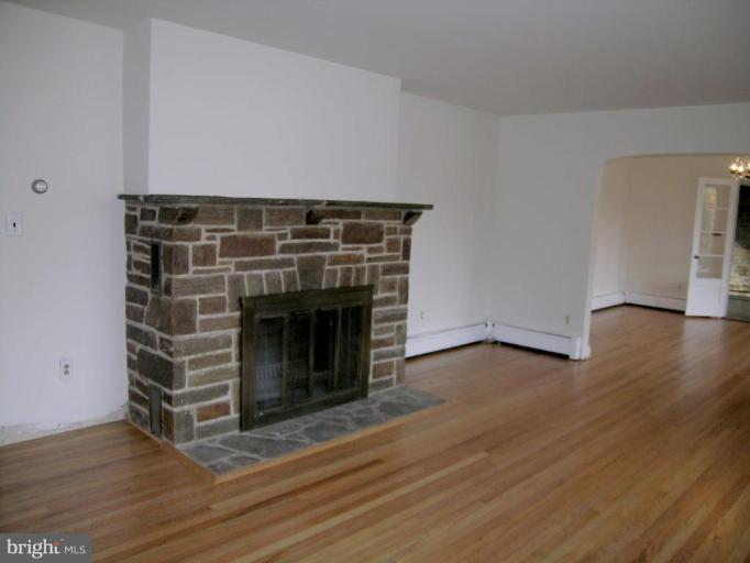9217 Frederick Road Ellicott City, MD 21042 - Photo 10 of 22 a view of an empty room with wooden floor and a fireplace