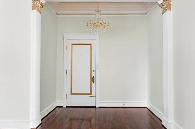 a view of a hallway with wooden floor and a window