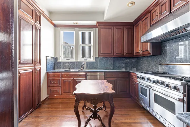 a kitchen with stainless steel appliances granite countertop a stove a sink and a refrigerator