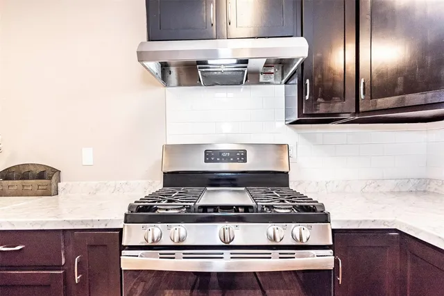 a stove sitting inside of a kitchen with kitchen island