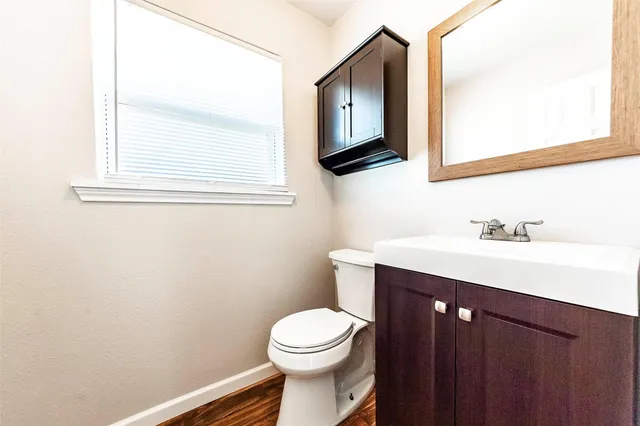 a bathroom with a toilet a sink a vanity and mirror