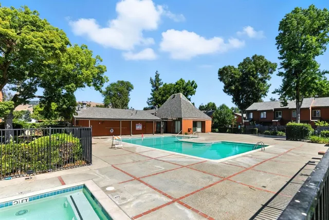 a front view of a house with a yard and potted plants