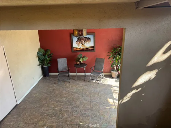 a room with painting on the wall and a potted plant