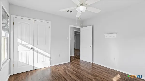 a view of an empty room with wooden floor