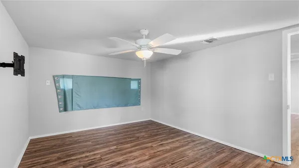 wooden floor in an empty room with a window