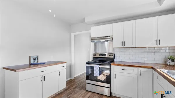 a kitchen with white cabinets stainless steel appliances and sink