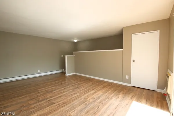 a view of an empty room with wooden floor