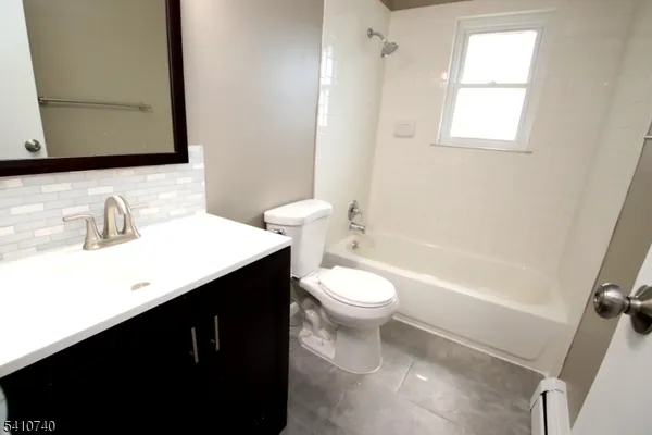 a bathroom with a sink a toilet a mirror and bathtub