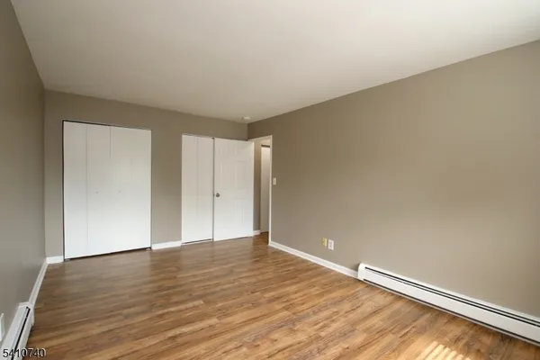 a view of an empty room with wooden floor