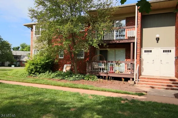 a front view of a house with garden and sitting area