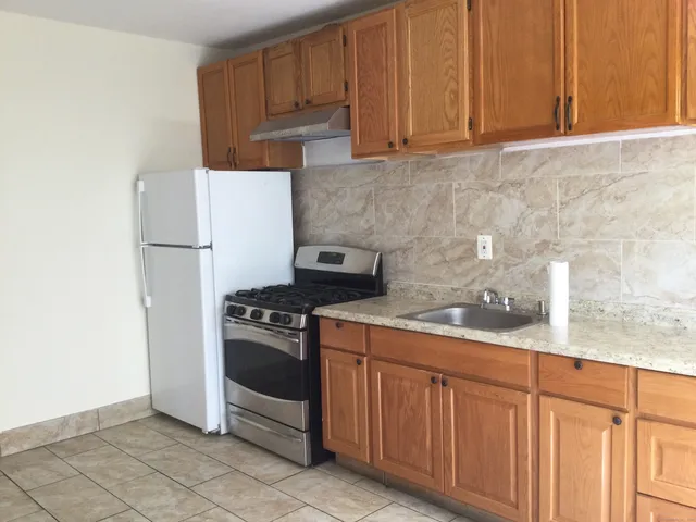 a kitchen with granite countertop cabinets and white appliances
