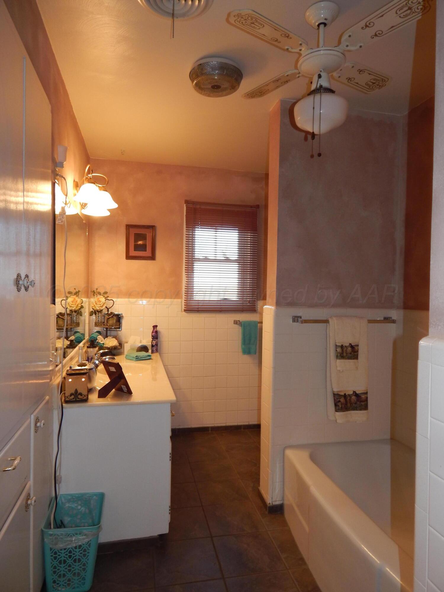 4205 Highway 83 Wellington, TX 79095 - Photo 23 of 52 a bathroom with a tub sink and mirror