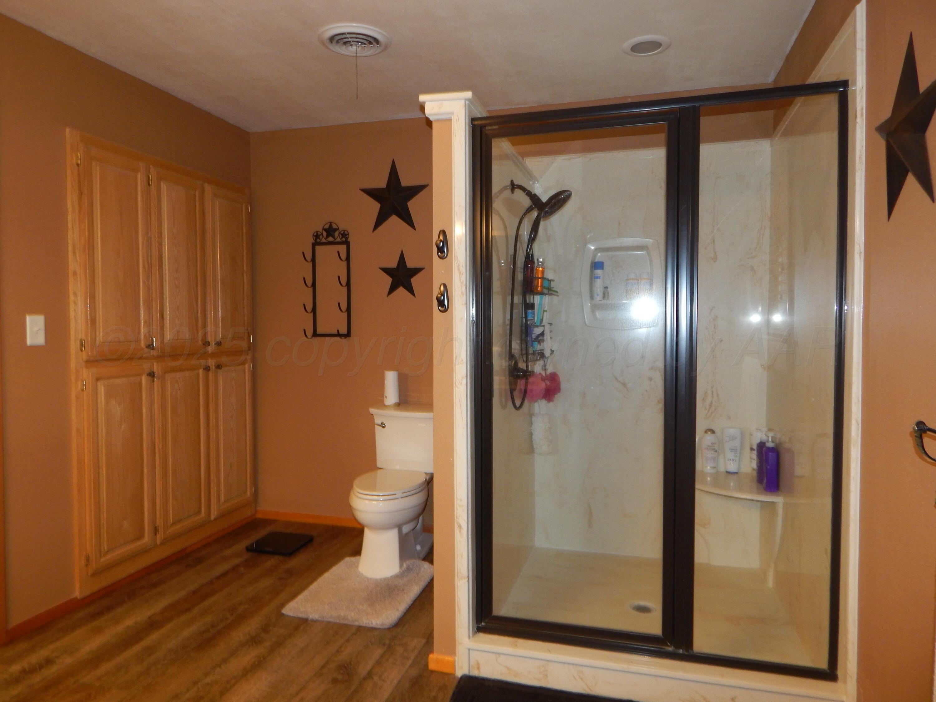 4205 Highway 83 Wellington, TX 79095 - Photo 28 of 52 a bathroom with a glass shower door