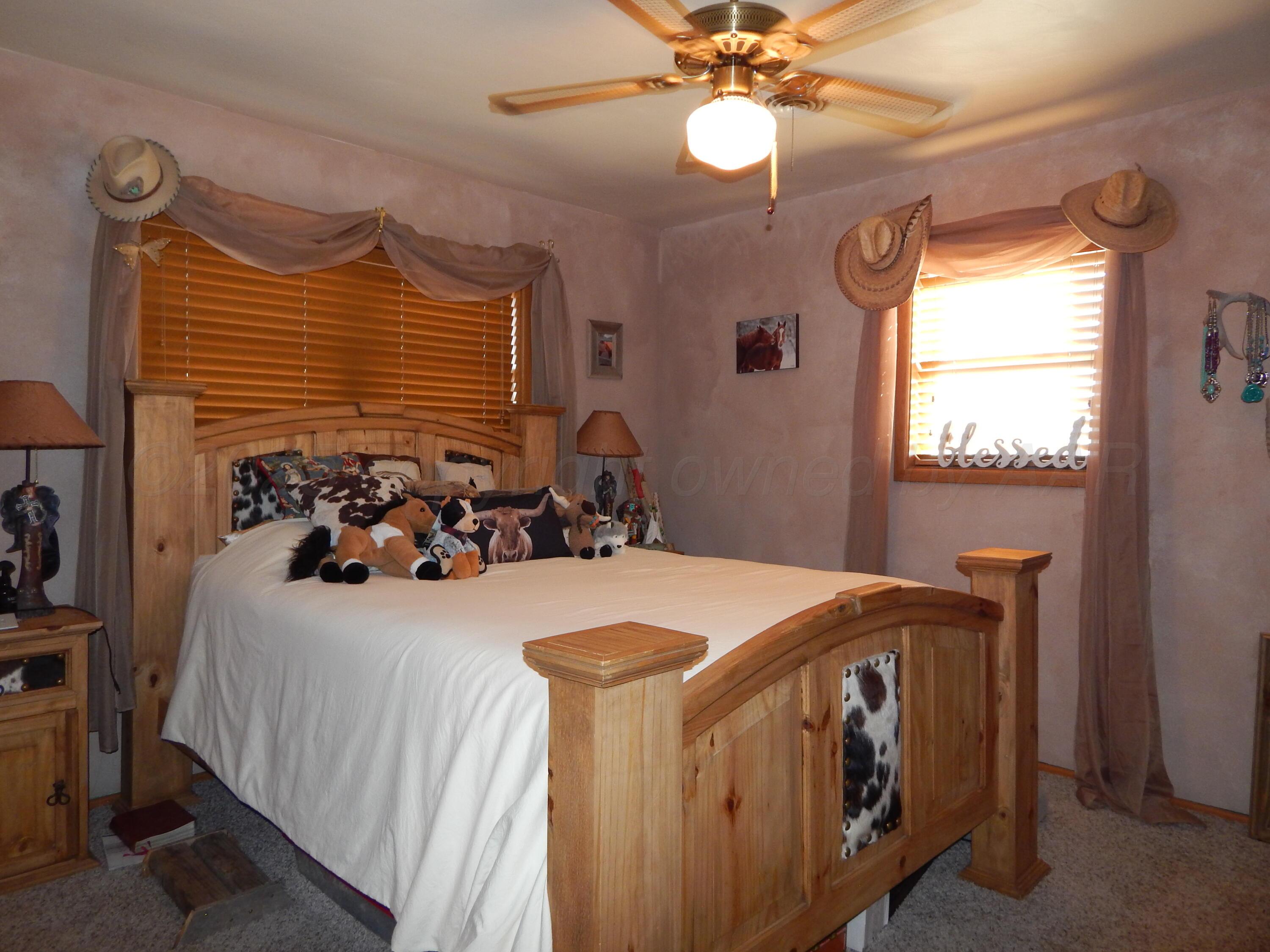 4205 Highway 83 Wellington, TX 79095 - Photo 32 of 52 a bedroom with a bed and a chandelier