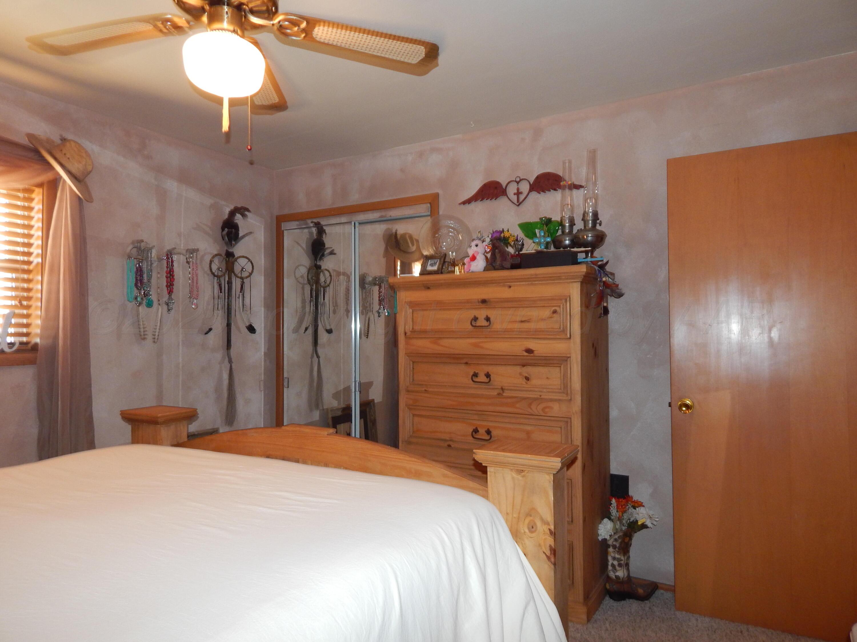 4205 Highway 83 Wellington, TX 79095 - Photo 33 of 52 a bedroom with a bed and a chandelier