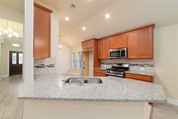 a kitchen with stainless steel appliances granite countertop a sink a stove and a granite counter tops
